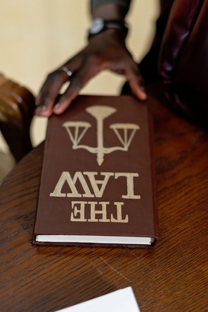Hand holding a law book above a wooden table